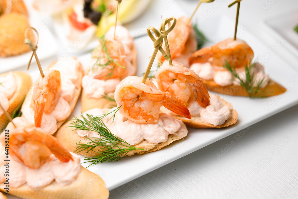 Appetizer canape with shrimp and sauce and white bread on plate on table. Appetizer canape with shrimp and sauce and white bread on plate on table.
