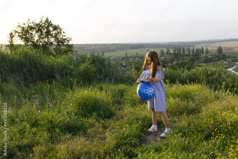 happy girl with red hair and blue dress having fun with an balloon in nature happy girl with red hair and blue dress having fun with an balloon in nature