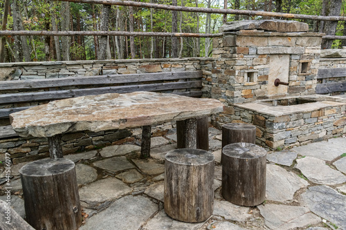 A place for rest during hiking, a table from a stone plate, and chairs from wooden stumps.