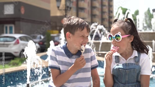 children eat ice cream in the summer near the fountain