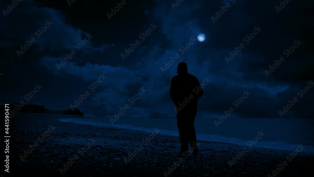 Man Walks Along Beach And Looks Out At Night Man Walks Along Beach And Looks Out At Night