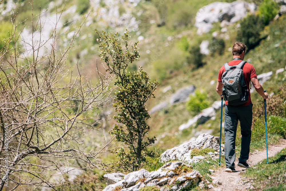 Traveler with backpack trekking on cliff