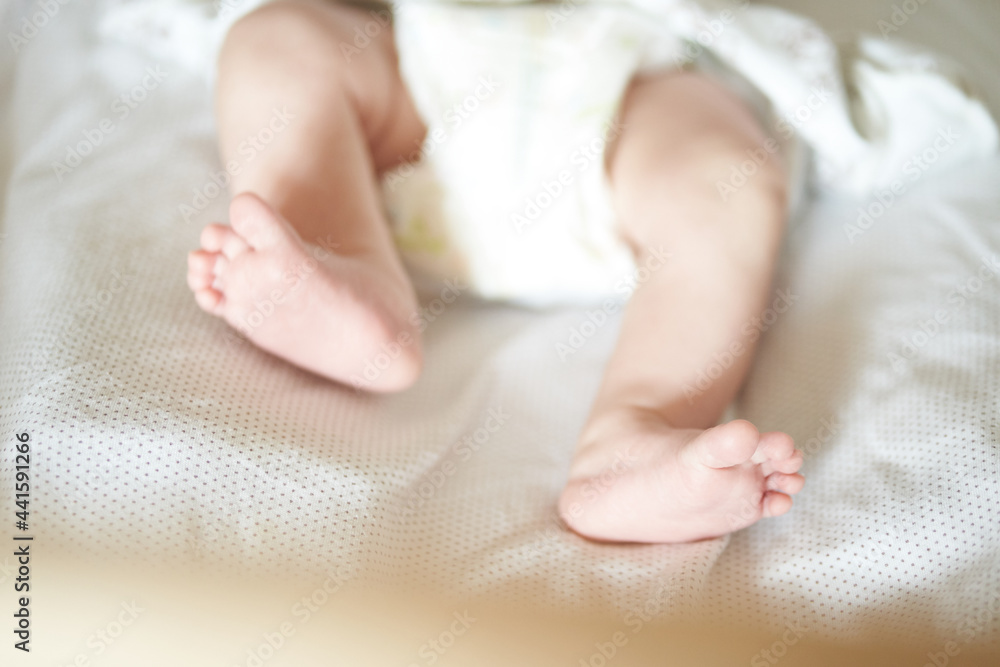 Baby legs on white sheet, newborn baby 1 month, care and love with copy space. High quality photo Baby legs on white sheet, newborn baby 1 month, care and love with copy space. High quality photo