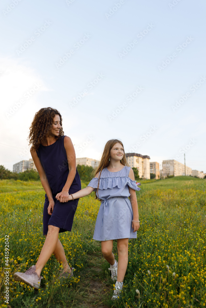 young red-haired mom and her wonderful red-haired daughter have fun outdoors dressed in dresses young red-haired mom and her wonderful red-haired daughter have fun outdoors dressed in dresses