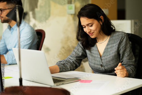 Happy businesswoman working on laptop. Portrait of beautiful businesswoman in the office..