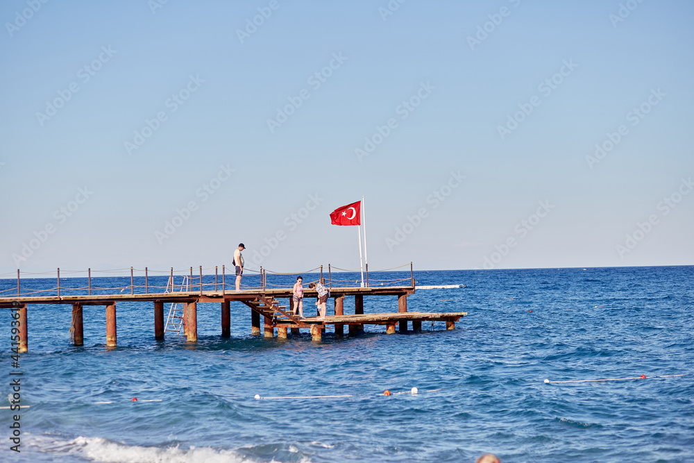 View of the Mediterranean sea and turkish flag at sunset. Summer wallpaper or print