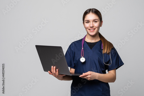 Beautiful Caucasian woman doctor or nurse holding a laptop computer isolated on a white background © dianagrytsku