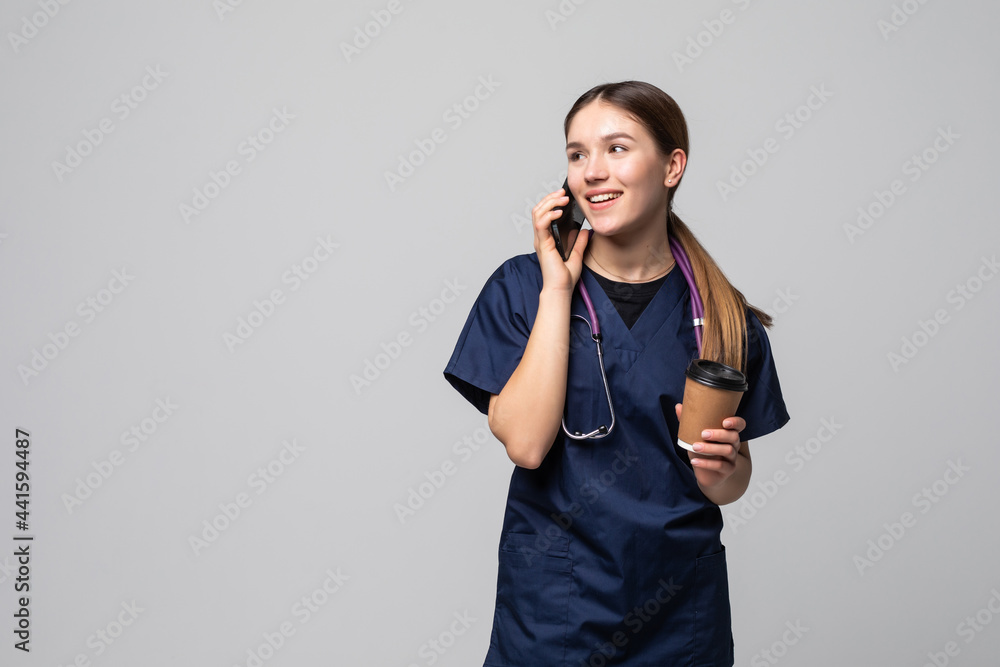 Smiling doctor woman talking cell phone isolated on white background Smiling doctor woman talking cell phone isolated on white background