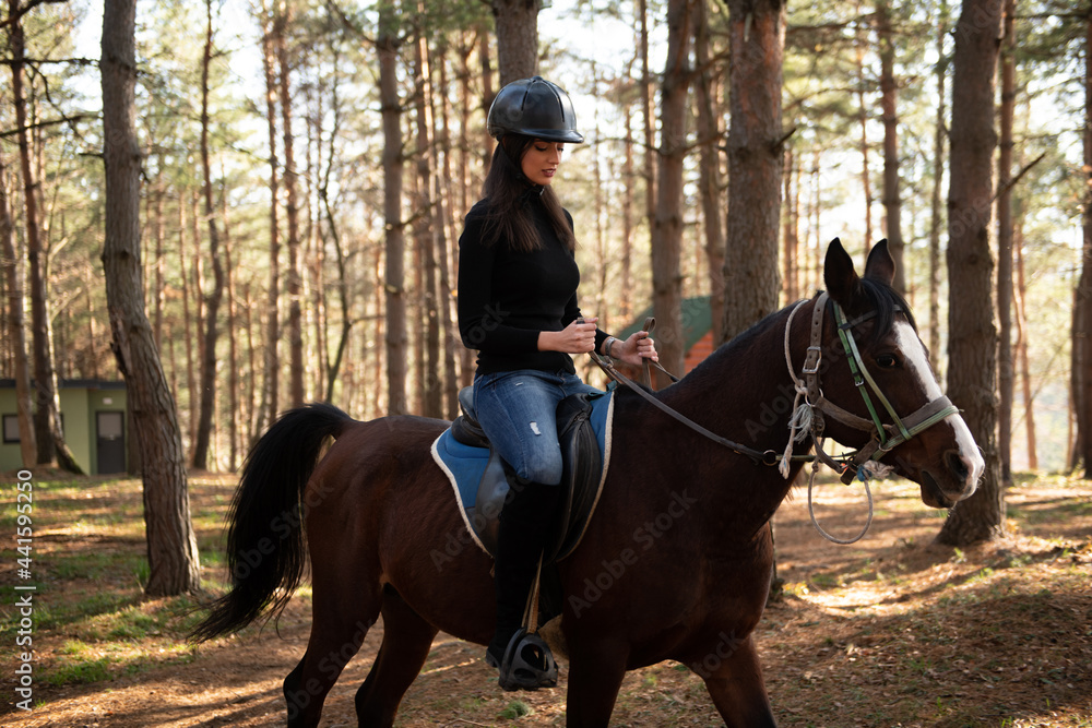 Girl With Helmet Riding a Horse in Forest Girl With Helmet Riding a Horse in Forest