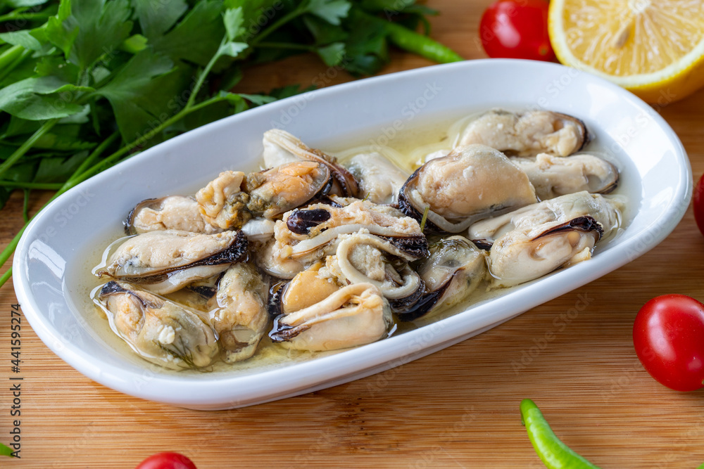 Close-up marinated mussels on wooden background. Seafood dishes. local name marineli midye Close-up marinated mussels on wooden background. Seafood dishes. local name marineli midye