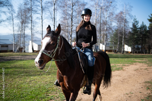 Beautiful Woman Rides a Horse Wearing a Helmet