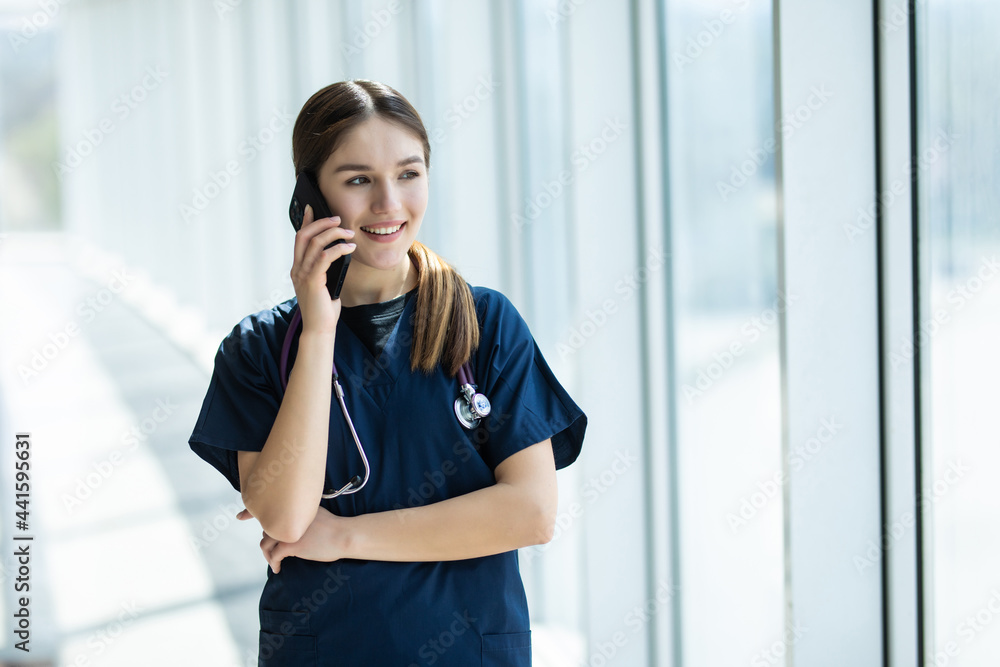 Young female doctor talking on the phone and smiling Young female doctor talking on the phone and smiling