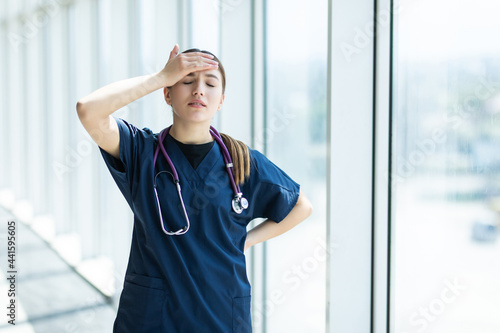 Young sad female nurse at hospital corridor