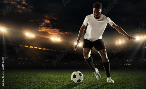 One African man, male football or soccer player training at stadium - motion, action, activity concept © master1305