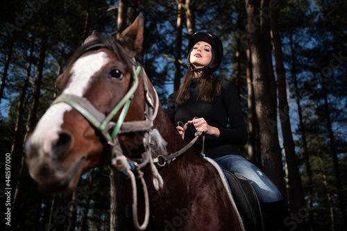 Girl With Helmet Riding a Horse in Forest