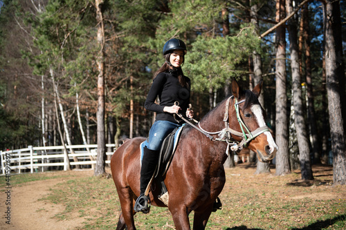Young Woman Wearing Helmet and Riding Horse © Jale Ibrak