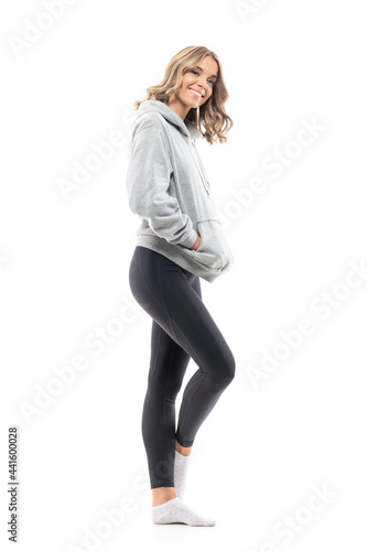 Side view of happy young pretty woman in casual sporty clothes smiling. Full body length isolated on white background.