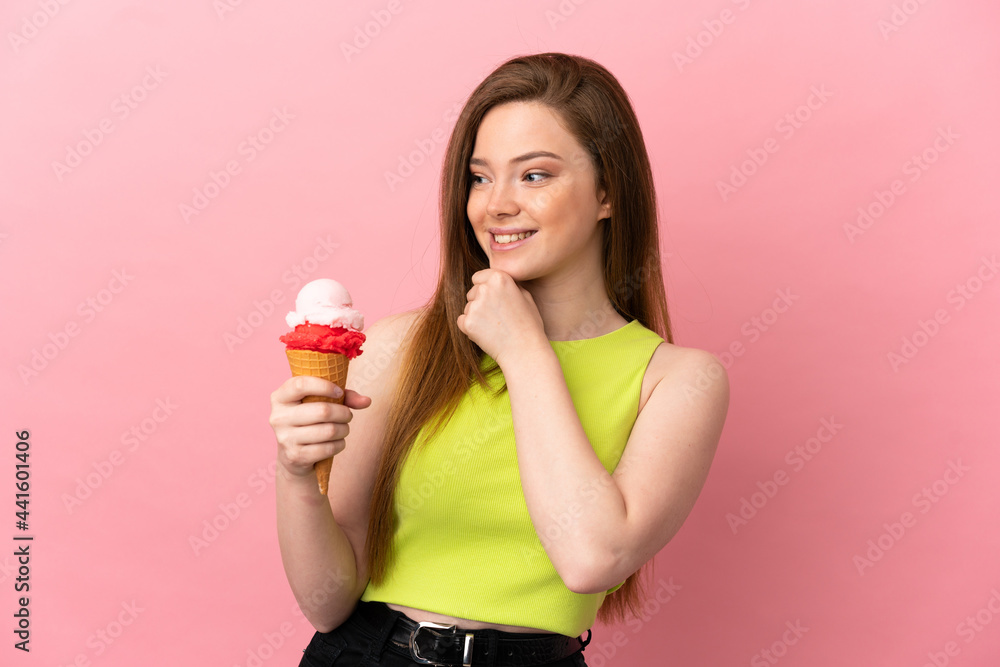 Teenager girl with a cornet ice cream over isolated pink background looking to the side and smiling Teenager girl with a cornet ice cream over isolated pink background looking to the side and smiling