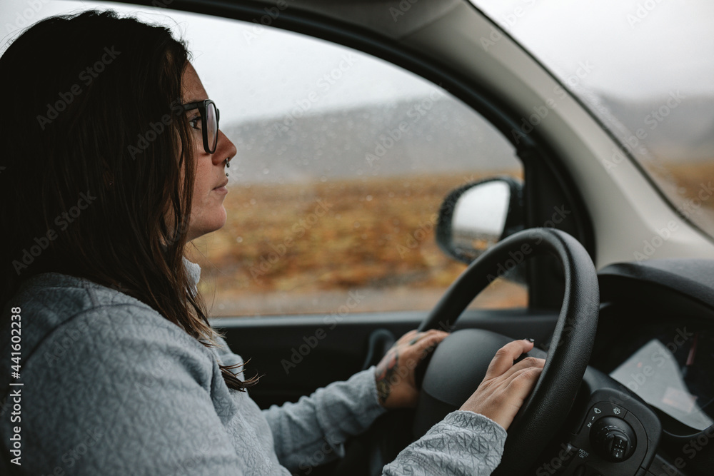 Woman driving car between wild lands Woman driving car between wild lands