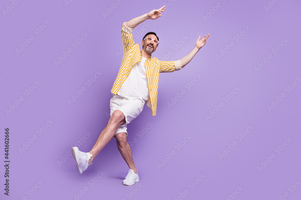 Fototapeta premium Photo of funky sweet mature man dressed striped shirt spectacles walking dancing empty space smiling isolated violet color background
