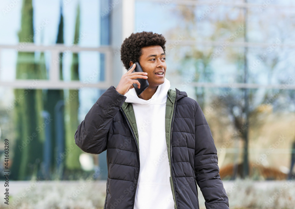 Smiling black man talking on smartphone on city street Smiling black man talking on smartphone on city street
