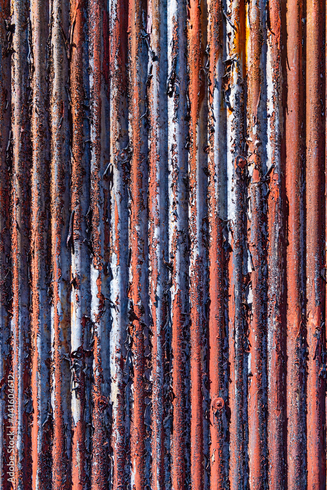 赤いペンキが剥がれて劣化したトタン板