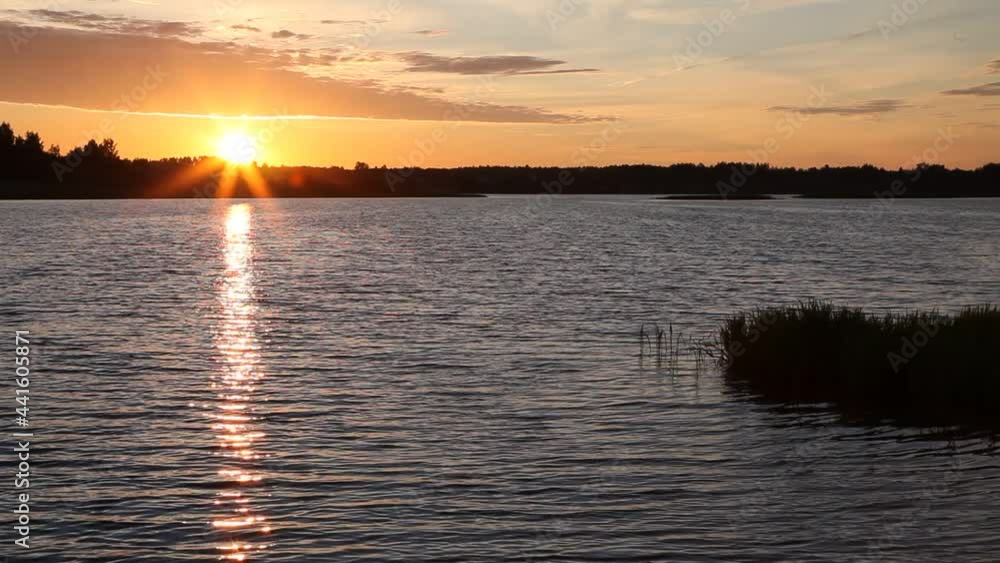 Beautiful orange sunrise in Russia on the Volga River with a Sun in the sky and a forest on the horizon in the calm water reflection on a summer morning, Russian natural landscape Beautiful orange sunrise in Russia on the Volga River with a Sun in the sky and a forest on the horizon in the calm water reflection on a summer morning, Russian natural landscape
