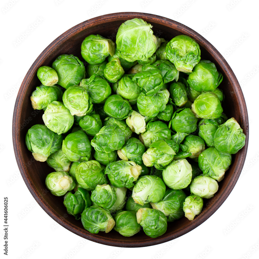 Brussel sprout or Rosenkohl in German language in a clay bowl on a white background. Brussel sprout or Rosenkohl in German language in a clay bowl on a white background.