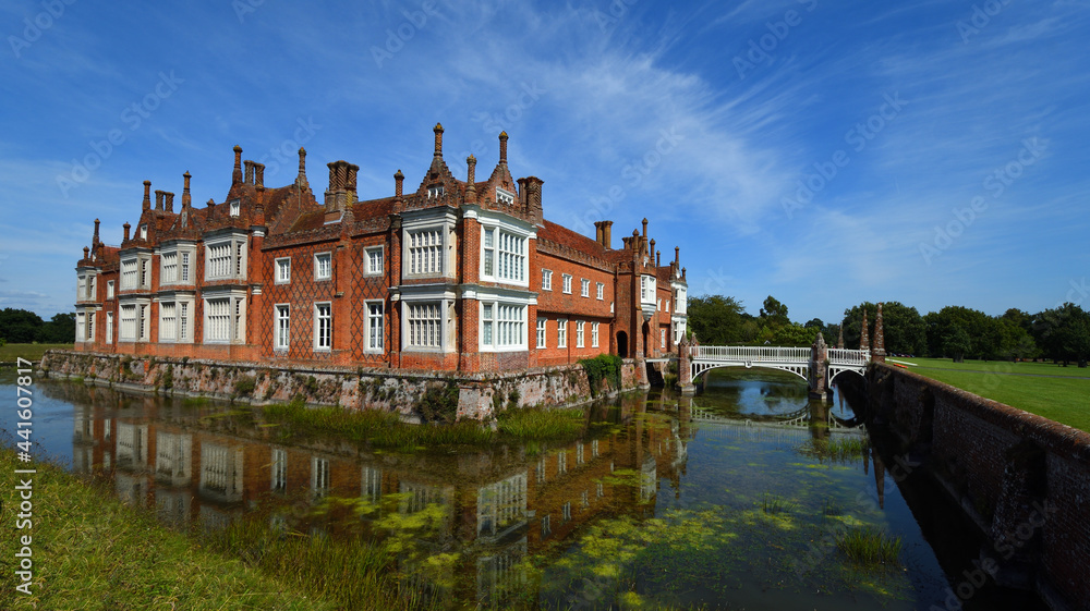 Helmingham Hall with moat bridges and reflections.