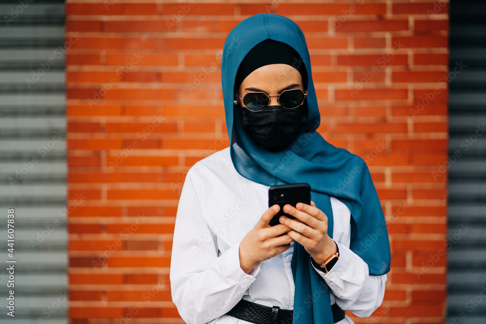Ethnic woman in hijab and mask in city Ethnic woman in hijab and mask in city