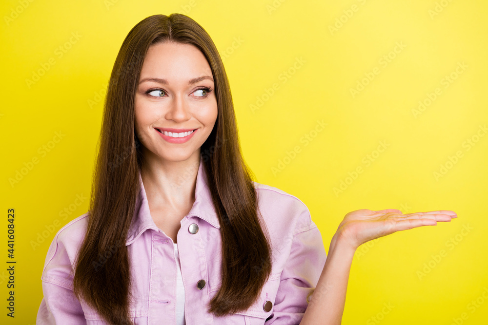 Photo of curious brunette hairdo millennial lady hold empty space wear pink shirt isolated on yellow color background Photo of curious brunette hairdo millennial lady hold empty space wear pink shirt isolated on yellow color background