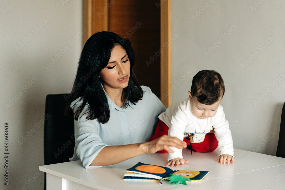 Young mother and little son reading childrens book together Young mother and little son reading childrens book together
