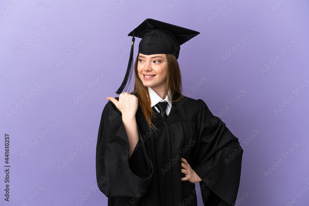 Young university graduate over isolated purple background pointing to the side to present a product Young university graduate over isolated purple background pointing to the side to present a product