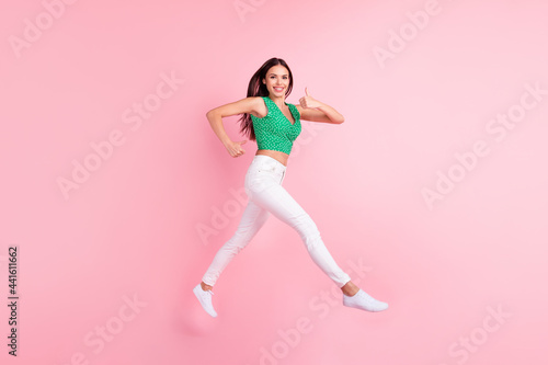 Full length body size photo smiling jumping up showing like sign running on sale isolated pastel pink color background