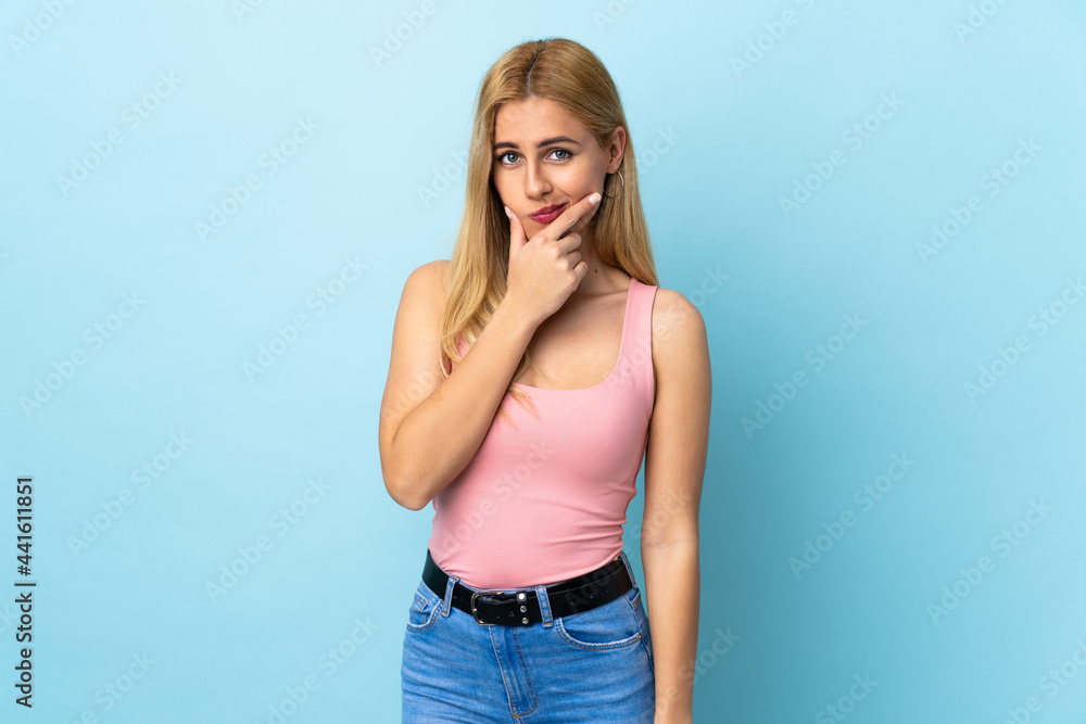 Young Uruguayan blonde woman over isolated blue background having doubts Young Uruguayan blonde woman over isolated blue background having doubts