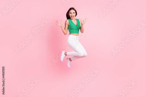 Full length body size photo woman in casual outfit smiling jumping high amazed isolated pastel pink color background