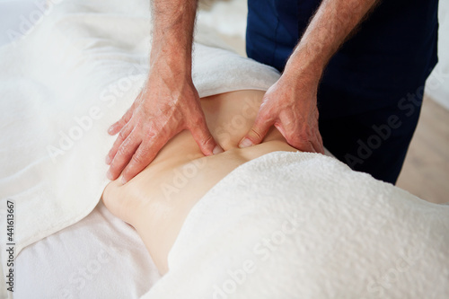 Hands of doctor masseur chiropractor pushing on back points and making acupressure treatment for woman patient. Beauty treatment, massage bodycare in medical clinic from professional