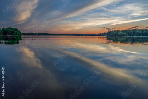 Bright sunset with reflections of clouds on the calm water during summer on Big Moon Lake  Barron County WI 