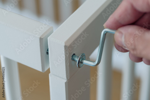 close-up of person assembling furniture using a hex key