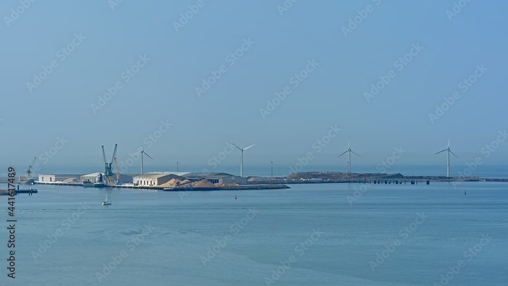 Industrial sea harbor of Boulogne sur mer, Oise, France, with windmills and hangars 