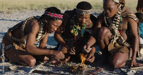 Close-up portrait view of tribal San people (Bushmen) making a fire in the traditional way photo