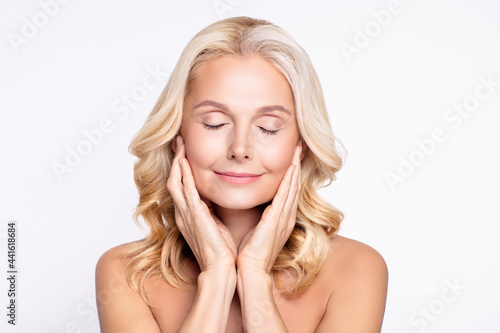Portrait of attractive dreamy middle-aged woman touching fresh silky skin massage isolated over white color background photo