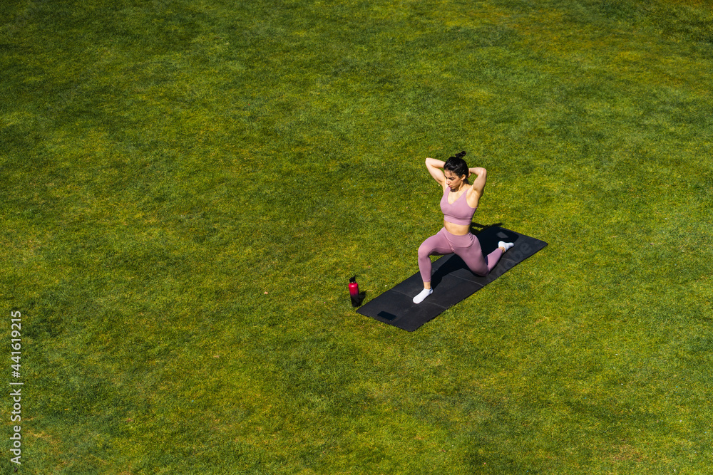 Woman performing Crescent Lunge on Knee on yoga mat Woman performing Crescent Lunge on Knee on yoga mat