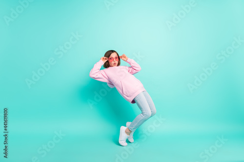 Profile full size photo of brunette hairdo funny small girl dance wear pink eyewear sportswear isolated on teal color background © deagreez