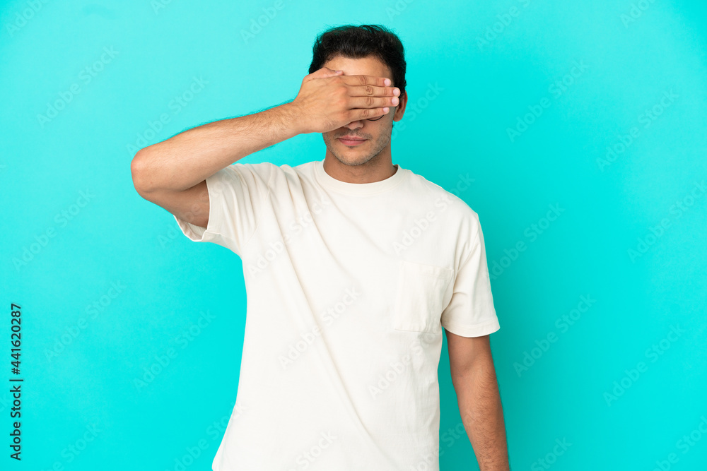 Caucasian handsome man over isolated blue background covering eyes by hands. Do not want to see something Caucasian handsome man over isolated blue background covering eyes by hands. Do not want to see something
