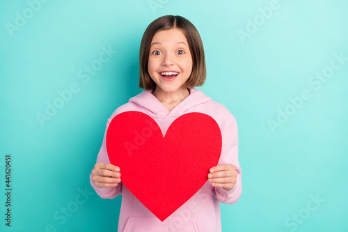 Photo of brunette hairdo impressed little girl hold paper heart wear pink sportswear isolated on teal color background
