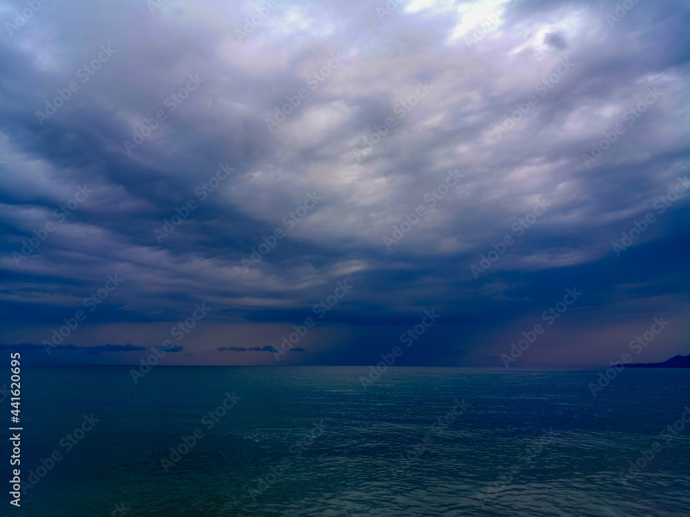 Obraz premium Amazing sea sunset on the pebble beach, the sun, waves, clouds