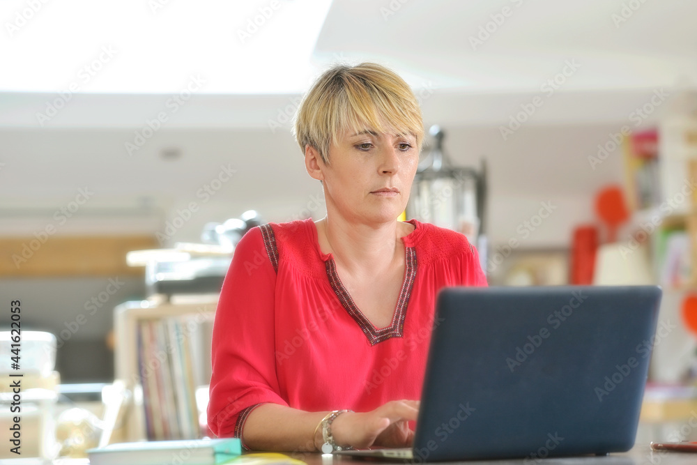 Female secretary working at home and attending at a conference call on her laptop. Female secretary working at home and attending at a conference call on her laptop.
