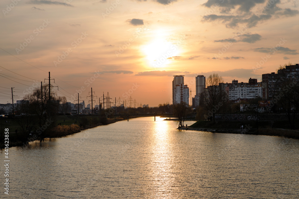 
Evening city landscape with a panorama of high-rise buildings. City sunset by the lake.