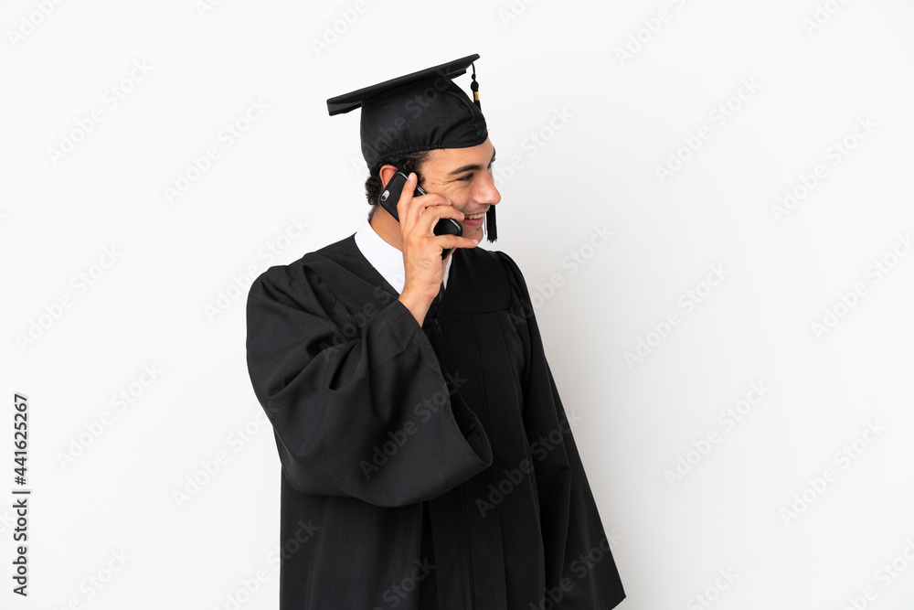 Young university graduate over isolated white background keeping a conversation with the mobile phone with someone Young university graduate over isolated white background keeping a conversation with the mobile phone with someone
